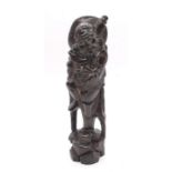 A 20th Century carved Chinese style wooden figure of a deity, with inlaid floral detail. Approx.