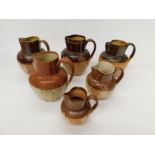 A small collection of Royal Doulton, Doulton Lambeth and similar stoneware handled jugs to