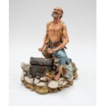 A large Capo Di Monte figure of a pirate with a treasure chest.
