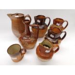 A collection of Victorian stoneware wine and water jugs with embossed detail, together with an early