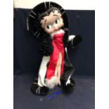 Large Betty Boop figure on stand with red dress and fur coat, 80cm high.