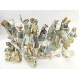 A collection of Lladro and Nao figurines, mostly of children, a golfer, a lady sitting on a chair,