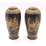 A pair of Japanese pottery vases, decorated with gilt detail to a black background, the designs