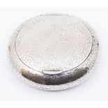 An Arts & Crafts silver circular mottled tobacco box and cover, hallmarks indistinct, date letter