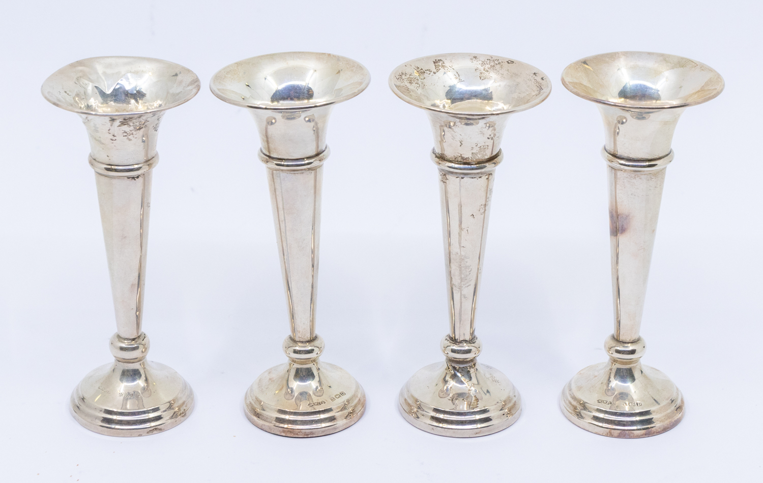 A matched set of four George V silver posy vases, filled, hallmarked Birmingham, various makers,