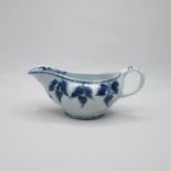 A Bow porcelain blue and white  sauce boat with a moulded relief of hanging fruits or nuts, over a