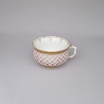 A French porcelain  pink reticulated cup, inside painted with a flower spray and gilt border and a