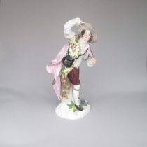 A Meissen mid 19th century figure of a man holding a cloak over his shoulder and a bag to his