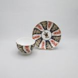 A Chelsea Derby Tea bowl and Saucer, painted with a Queen Charlotte style pattern in red blue and
