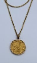 A yellow metal moghul type coin, in a mount, on a 9ct marked chain