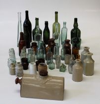 A coolection of several dozen, largely Edwardian glass bottles and jars, variously named, together