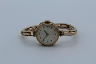 A 9ct gold cased watch, the circular dial with Arabic numerals on 9ct yellow gold expanding