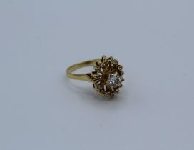 A diamond set celestial design dress ring featuring a central round brilliant cut diamond of an