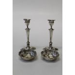 A pair of columnar loaded candlesticks along with a pair of pierced work silver bonbon dishes,