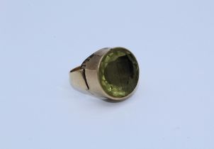 A yellow metal citrine intaglio ring featuring an intaglio with faceted pavillion and carved with