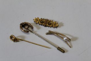 A late 19th century yellow metal horse shoe and stirrup stock pin, a 9ct gold bar brooch and a