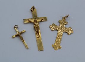 A collection of three 9ct gold crosses, comprising two plain crucifixes ( the largest measuring