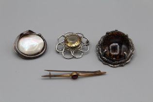 A selection of brooches, featuring a yellow metal garnet set bar brooch, marked ct, in a vintage