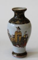 An early 20th century Japanese porcelain vase, decorated with figures and toad on an ivory black and