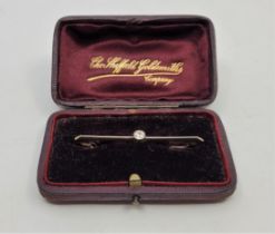 An Edwardian 15ct. gold and diamond bar brooch, bezel set single old-cut diamond, length 5.3cm. (