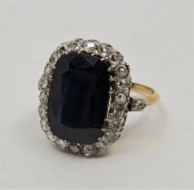 A large precious yellow metal, sapphire and diamond ring, claw set mixed cushion shape cut