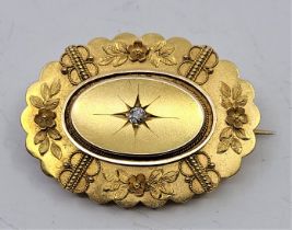 A Victorian 15ct. gold mourning brooch, of lobed oval form, illusion set single old-cut diamond to