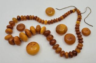 A string of graduated circular butterscotch amber beads, strung as a necklace, the largest