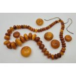 A string of graduated circular butterscotch amber beads, strung as a necklace, the largest