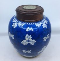 A Chinese porcelain Prunus blossom ginger jar, with turned wood and pierced jadeite inset cover,