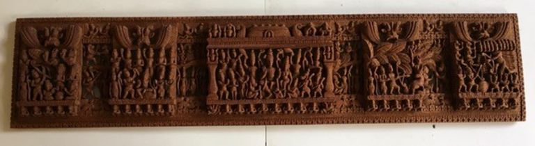 A large Indian carved wooden wall plaque. W: 123cm