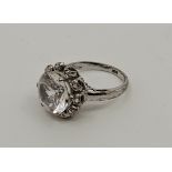 A white metal and clear topaz dress ring, set single mixed round cut clear topaz to centre, size