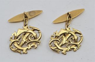 A pair of precious yellow metal cuff links, with pierced and engraved monogram fronts (yellow