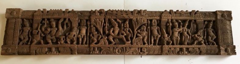 A large Indian carved wooden plaque. W: 123cm