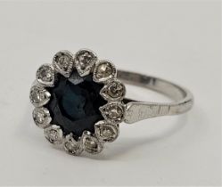 A white precious metal, sapphire and diamond cluster ring, set single mixed round-cut sapphire to