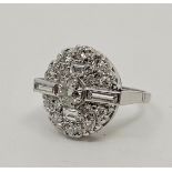 An 18ct white gold diamond cluster ring, having oval domed mount set round brilliant cut diamond