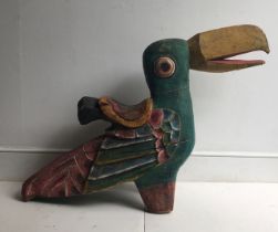 A novelty child's carved wooden chair fashioned as a parrot polychrome painted. H:64cm L:91cm