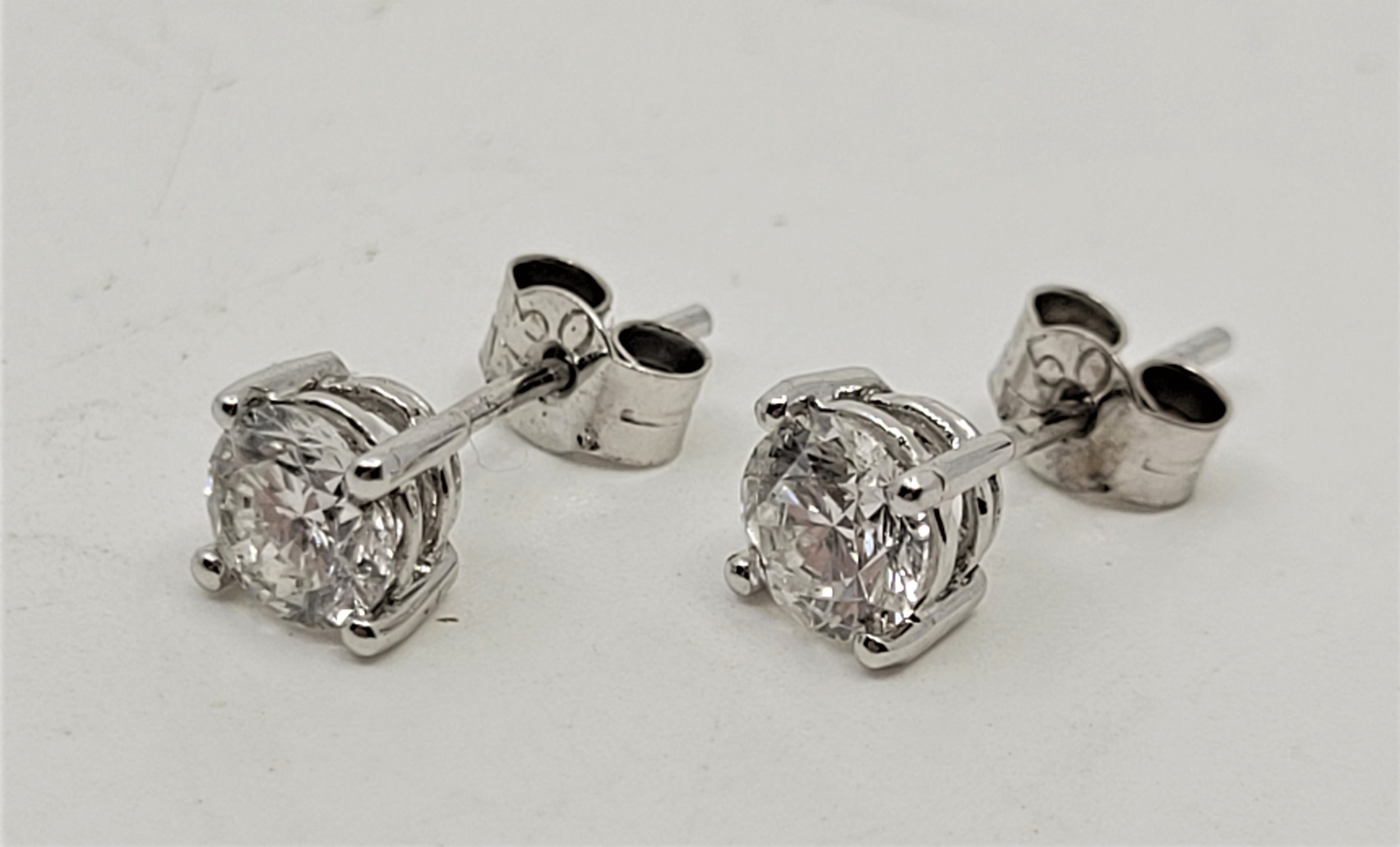 A pair of 18ct. white gold diamond stud earrings, each set single round-brilliant cut diamond of