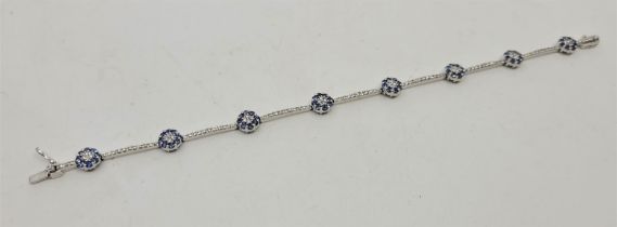 An 18ct. white gold, diamond and sapphire bracelet, formed from circular links each set four round