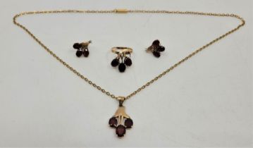A 14ct. gold and garnet pendant, ring and yellow metal mounted earrings en suite, the 14ct. gold