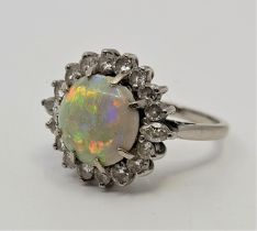 An 18ct. white gold, platinum, opal and diamond cluster ring, set circular cabochon opal to centre