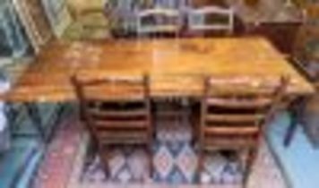 A 20th Century English provincial carved oak dining table with six ladder back dining chairs (4 +