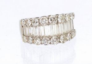 A diamond and 18ct white gold dress ring, comprising a central row of twenty tapering baguette cut