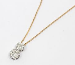 A diamond and 18ct gold set pendant, comprising a two round white gold mounts graduating in size,