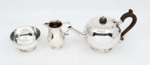 A Georgian style three piece silver tea service comprising bullet shaped teapot, pear shaped cream