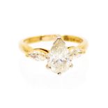 A diamond and 18ct yellow gold three stone ring, comprising a central pear cut diamond, approx 2.0