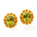 A pair of peridot and 18ct earrings, comprising a central oval mixed cut peridot approx 8 x 12mm,