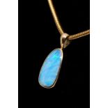 An opal and 18ct gold pendant and chain, comprising an irregular solid opal with green play of