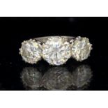 A three stone old diamond and platinum ring, comprising round brilliant cut diamonds, the