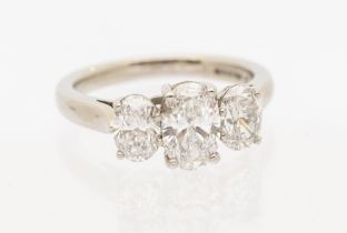 A diamond three stone 18ct white gold ring, comprising three graduated oval brilliant cut