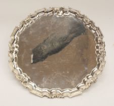 A George V silver salver, raised cut card border, plain reserve on three scroll supports, hallmarked